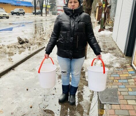 Photo was taken in Sviatohirsk, Donetsk Region. Olga, 55, a volunteer at the laundry set up by a CARE partner with her buckets.

80% of the buildings in town have been damaged or destroyed. There has not been any running water for nearly a year as the infrastructure has been severely damaged.
In Sviatohirsk a CARE partner has set up several water tanks to supply the residents with clean drinking water and water for showering, cleaning and cooking. Also a laundry was set up with the support of CARE, which is the only place in Sviatohirsk in which laundry washing is possible. Additionally, 40 houses have been repaired with the support of CARE and the renovation of another 325 is in process. Before the escalation of the war two years ago the village and surrounding settlements was home to 12,000 people. Now 2,700 remain of which 1,200 are elderly.

Olga, 55, is a volunteer at the laundry. They have 6 washing machines and 4 drying machines. The maximum of washing per day was 47 in the summer. Olga does not have a private water well in her own garden, so she needs to leave the house to gather the water for the day for her family.
&ldquo;Every morning I get up at 8 a.m. to carry 150 liters of water to my house with buckets, because that&rsquo;s what my family needs on a daily basis to cook, clean, shower or drink,&rdquo; explains Olga.